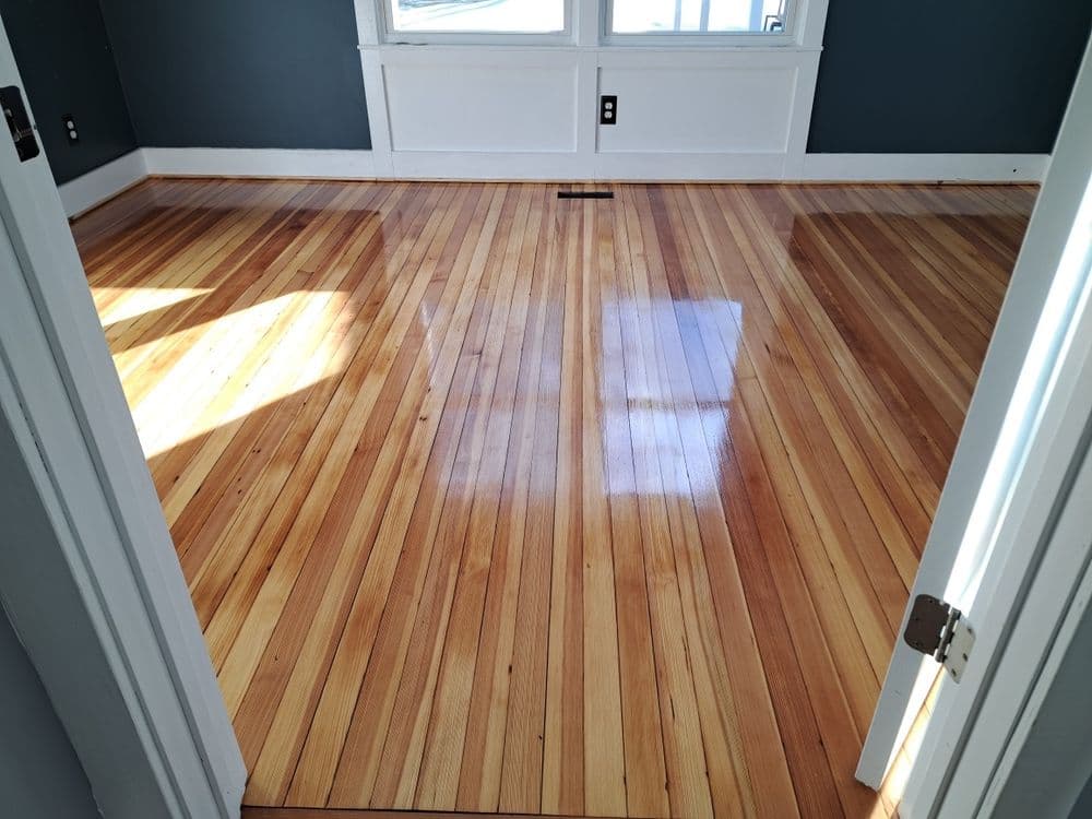 Bright room showcasing polished hardwood floors with natural light streaming in.